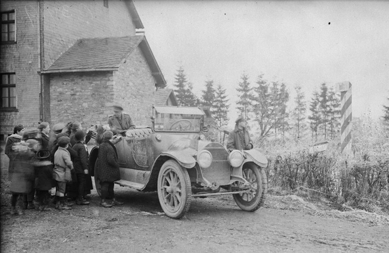 A Canadian car passing the Frontier between Belgium and Germany, surrounded by German and Belgian children. Dec. 1918. December 1918